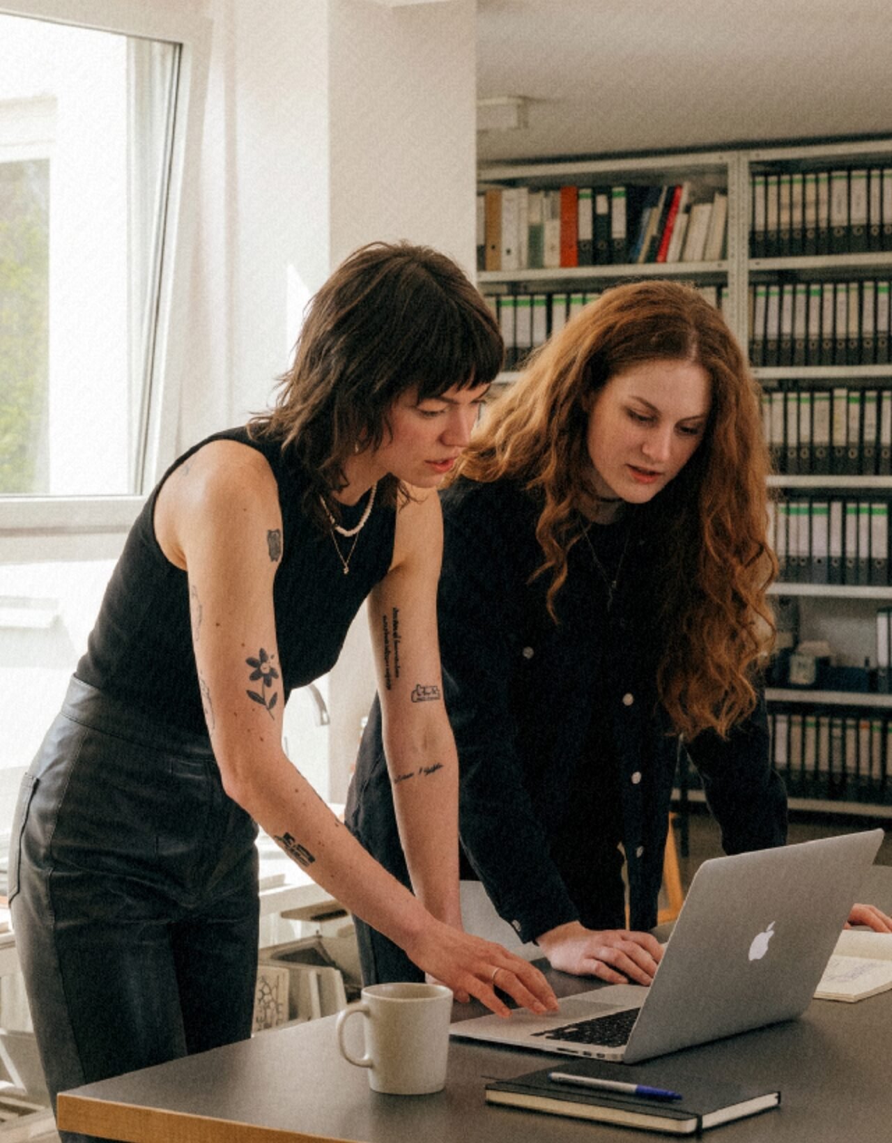 Iryna and Tanya, the UareUx founders, working at a laptop in the studio